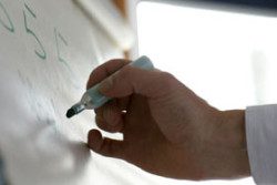 person writes on paper board