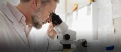 Image of a Medical Researcher looking through a Microscope